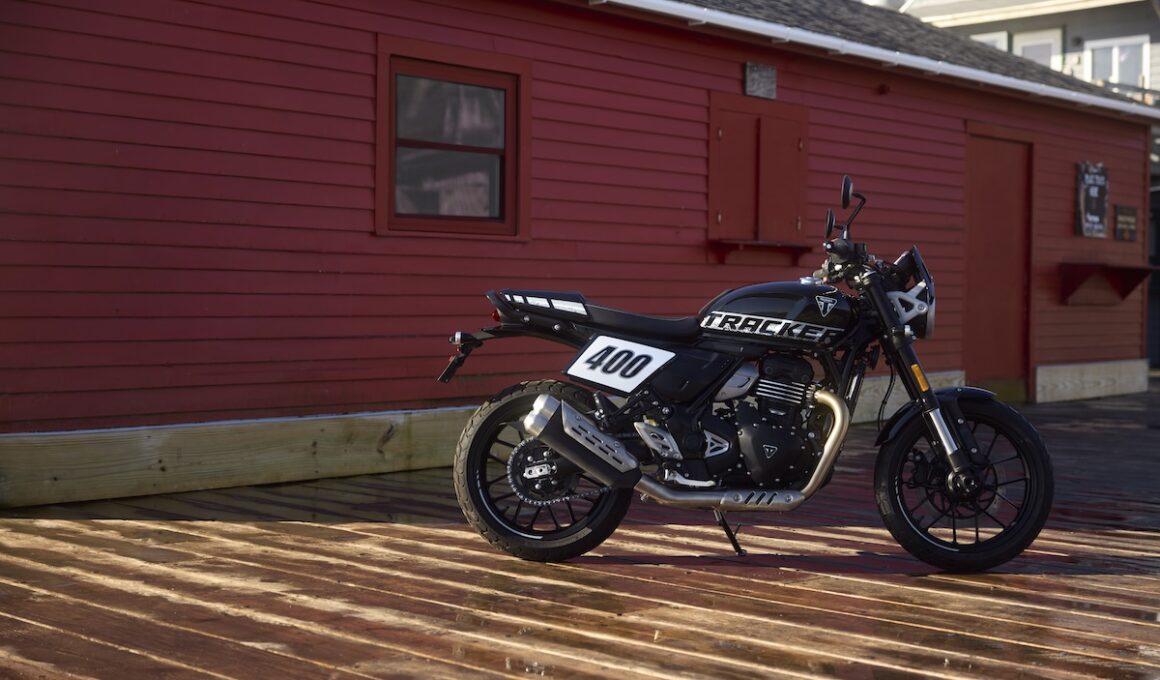 De Triumph Tracker op de zijstandaard op een houten vlonder