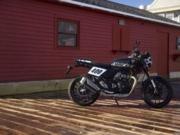 De Triumph Tracker op de zijstandaard op een houten vlonder