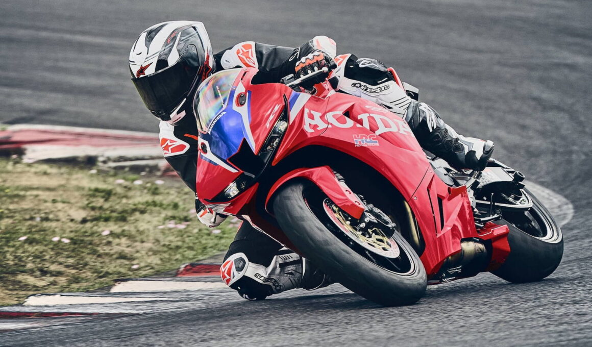 Honda CBR600RR 2027 in HRC-kleuren op het circuit, onder hellingshoek in een bocht