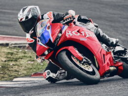 Honda CBR600RR 2027 in HRC-kleuren op het circuit, onder hellingshoek in een bocht