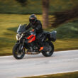 KTM 1390 Super Duke GT in bocht op openbare weg met zijkoffers, officiële persfoto uit 2024