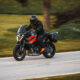 KTM 1390 Super Duke GT in bocht op openbare weg met zijkoffers, officiële persfoto uit 2024